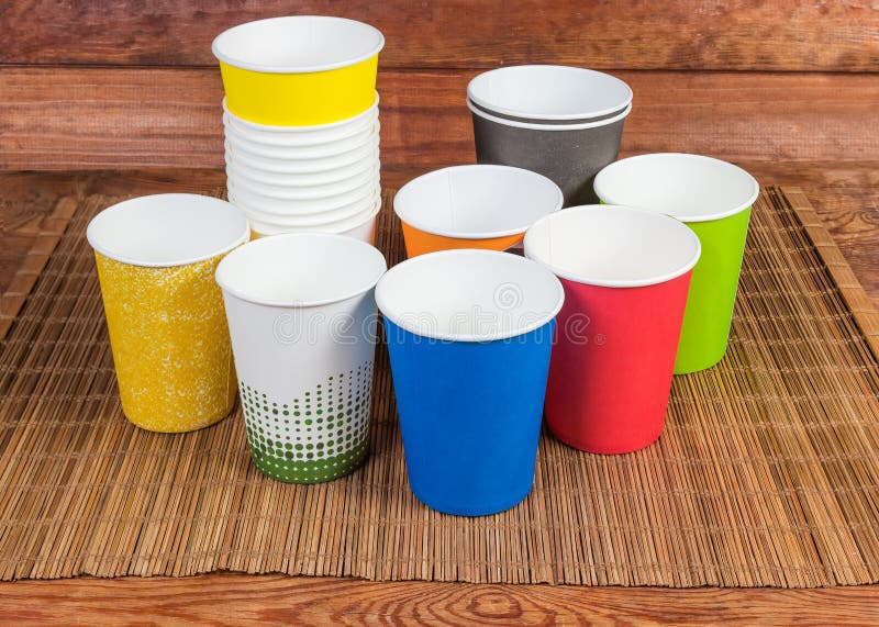 Different Empty Disposable Paper Cups on the Bamboo Table Mat Stock