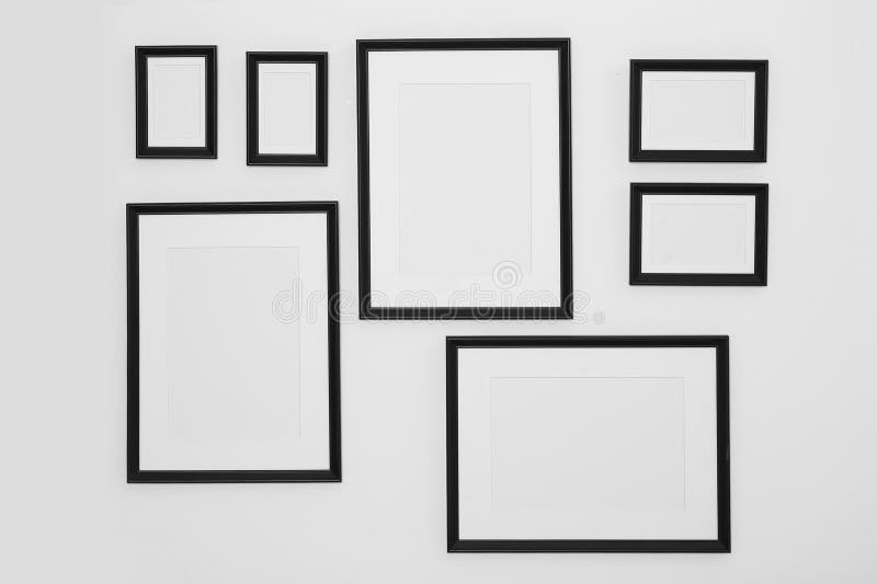 Different Empty Frames Hanging on White Wall Stock Photo - Image of ...