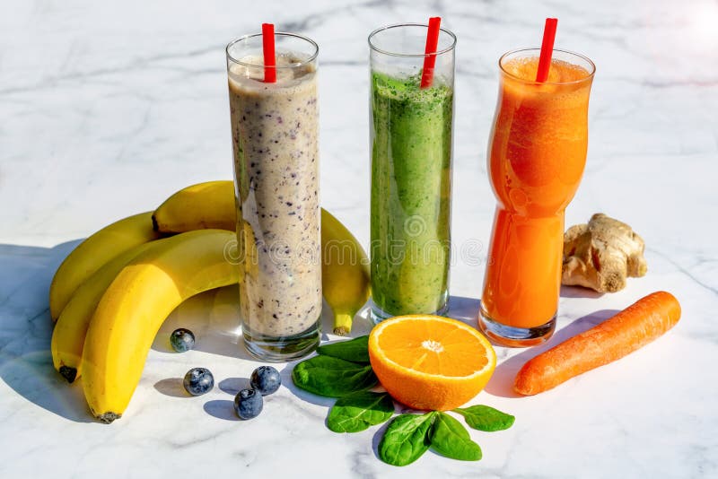 3 different kind of smoothies with ingredients on marble table background gigner banana blueberry spinach carrot