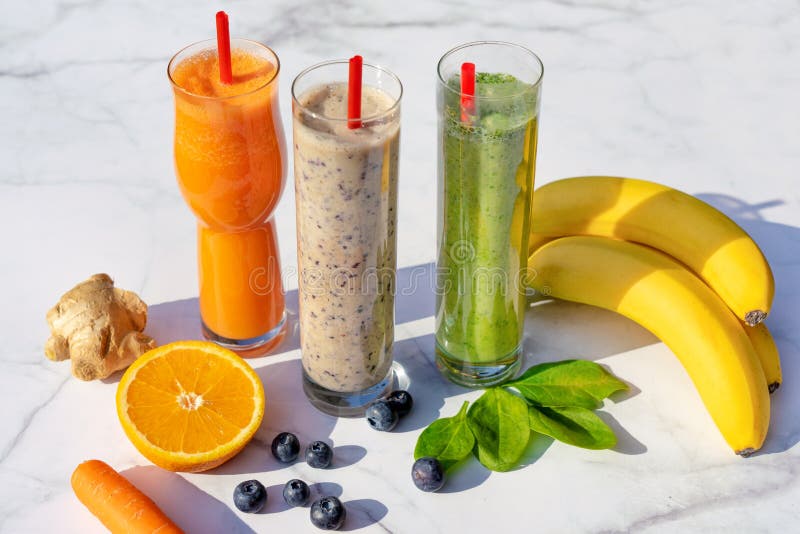 3 different kind of smoothies with ingredients on marble table background gigner banana blueberry spinach carrot