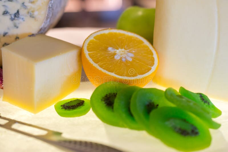 Different kinds of cheese with fresh fruits on table stock images