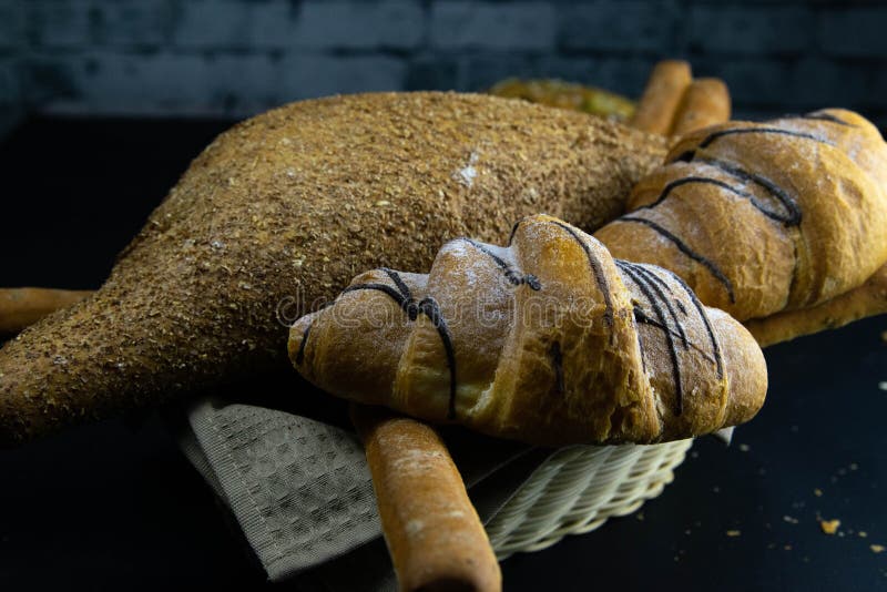 Different kinds of fresh bread with grain on black rustic background stock photos