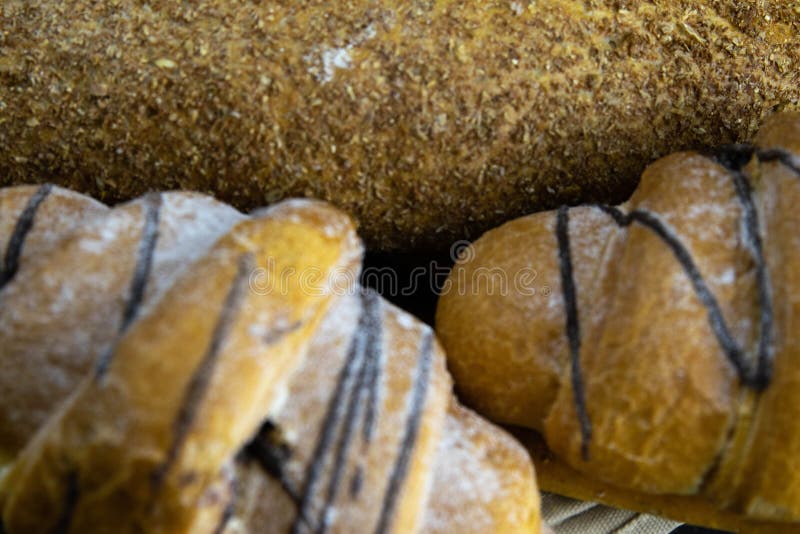 Different kinds of fresh bread with grain on black rustic background royalty free stock image