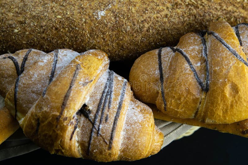 Different kinds of fresh bread with grain on black rustic background royalty free stock photos