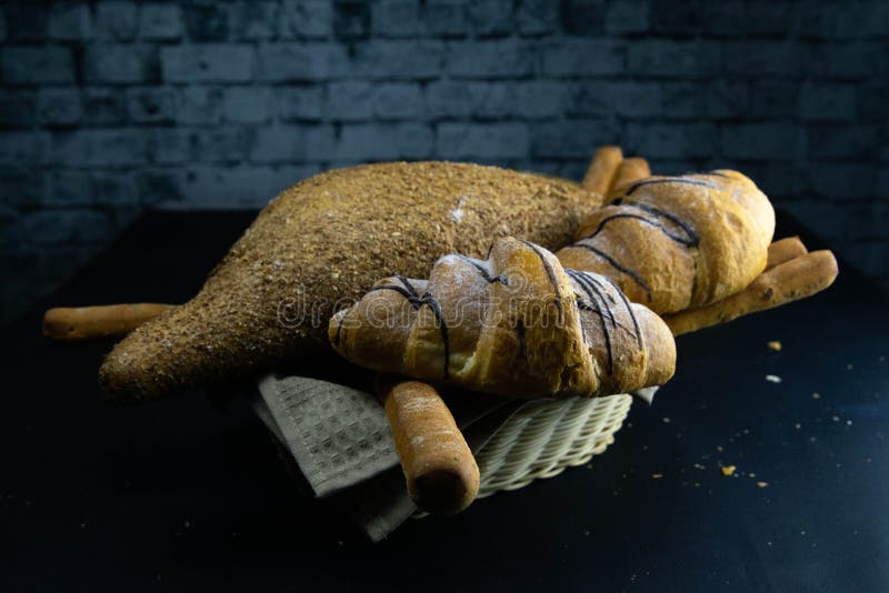 Different kinds of fresh bread with grain on black rustic background stock photos