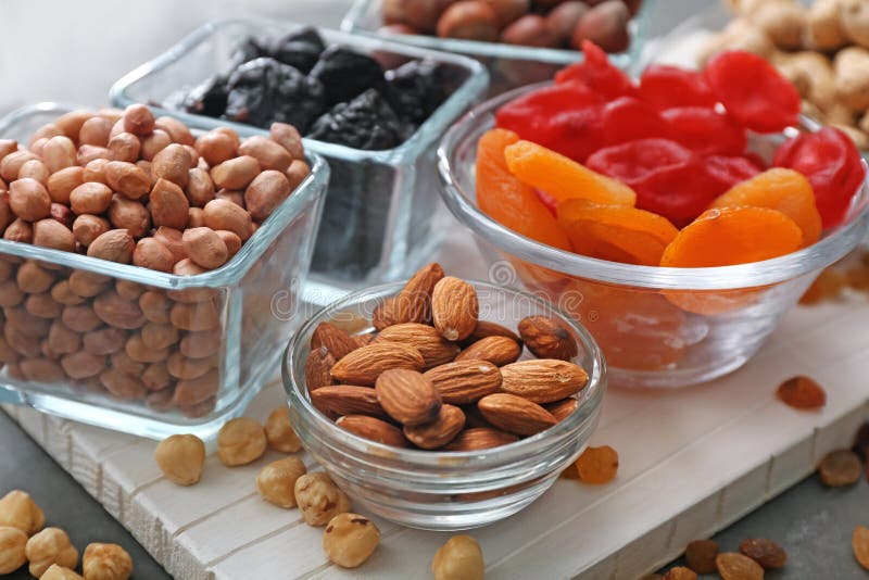 Different Kinds of Nuts and Dried Fruits in Bowls on Table, Closeup