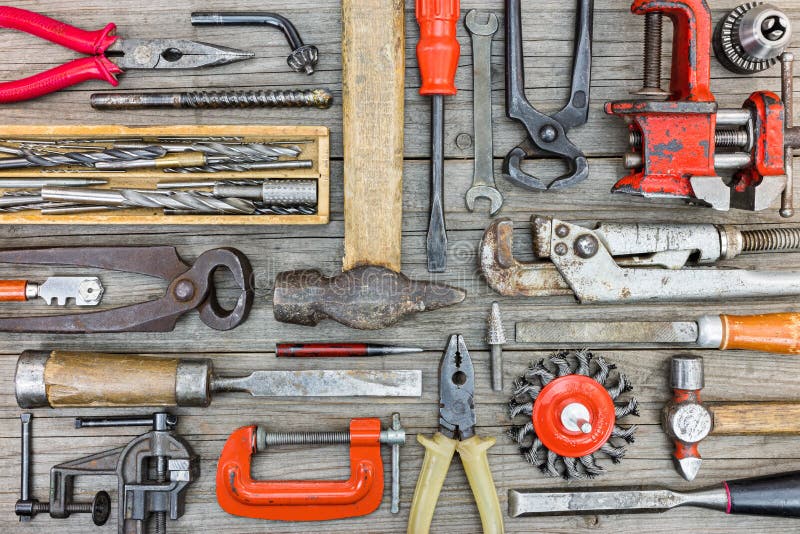 Different old rusty hand tools and accessories on gray wooden pl royalty free stock photography