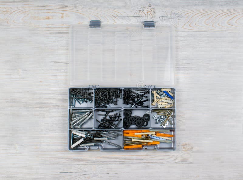 Plastic Case with Hardware Items Close Up. Isolated on a Wood