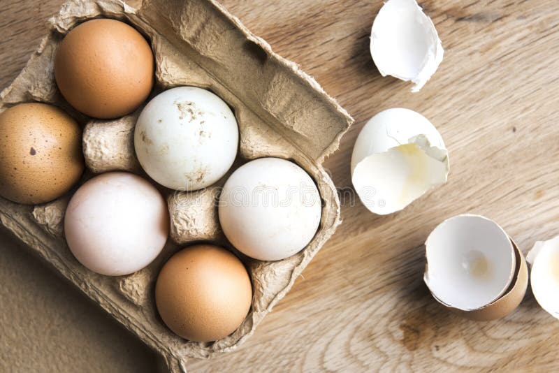 Different shades of farm fresh eggs on wood