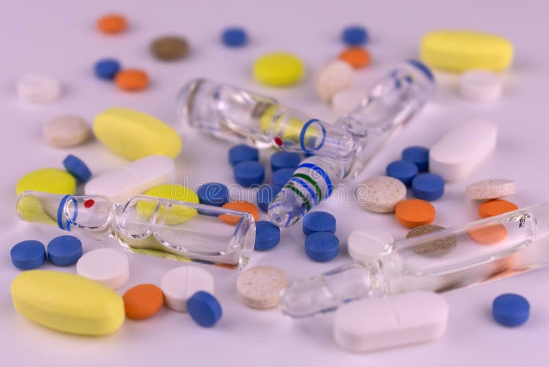 Different Tablets and Ampoules for Injections on a White Background