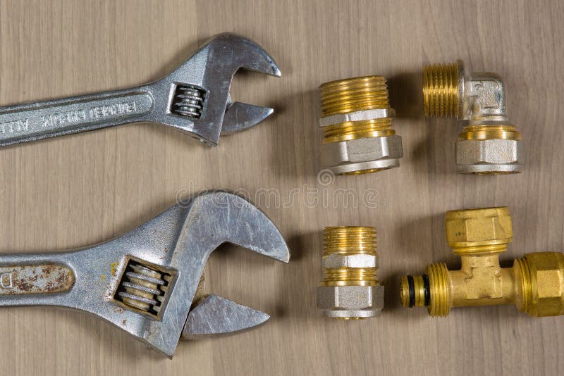 Different Tools on a Wooden Background. Adjustable Wrench and Parts for