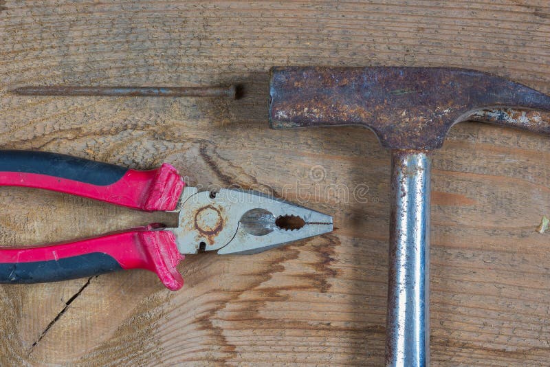 Different tools on a wooden background. Nails, hammer, pliers stock photo Different tools on a wooden background. Nails, hammer, pliers stock photo