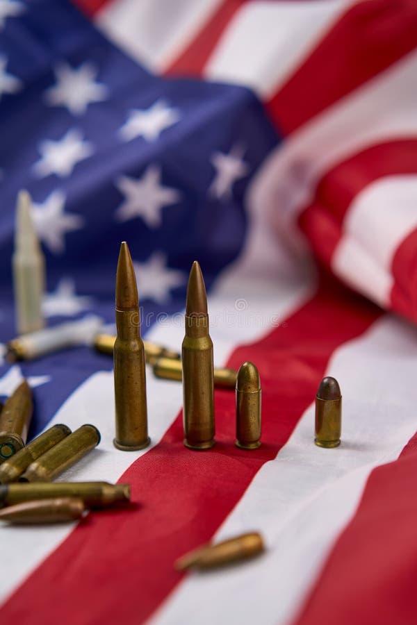 Ammunition of different sizes arranged in a row with a United States flag in the background. Types conflict stock images, royalty-free photos and pictures