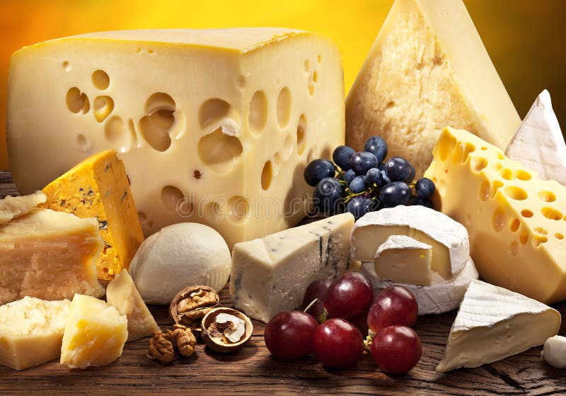Different types of cheese over old wooden table. stock photos