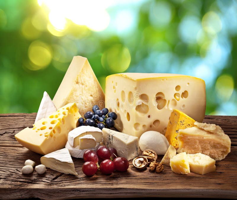 Different types of cheese over old wooden table. royalty free stock images