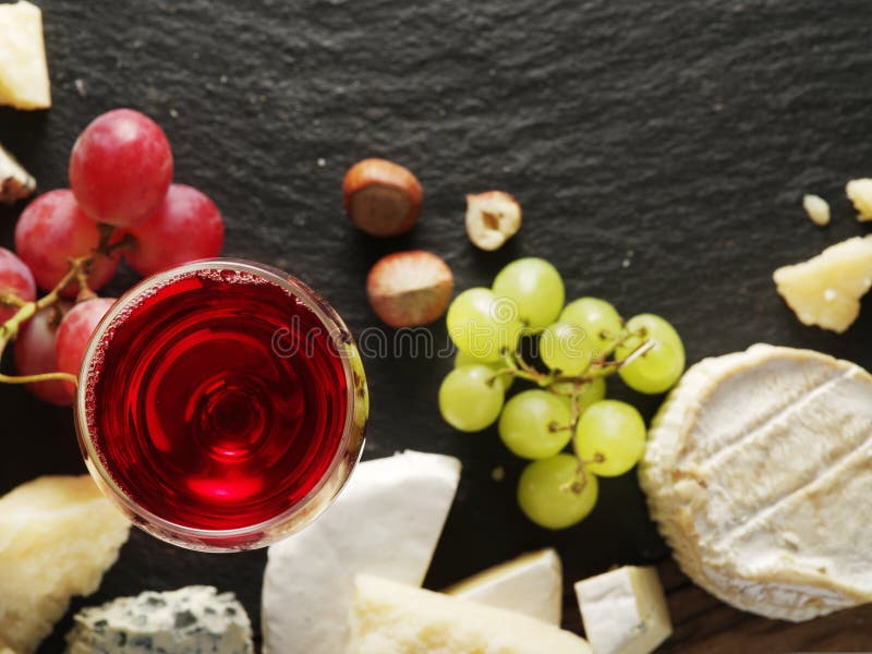 Different types of cheeses with wine glass and fruits. royalty free stock photography
