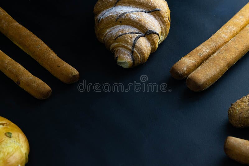 Different types of fresh bread with grain on a black rustic background. the bread stands around on top position stock photos