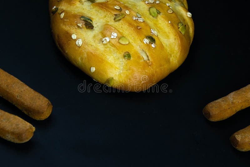 Different types of fresh bread with grain on a black rustic background. the bread stands around on top position royalty free stock photos
