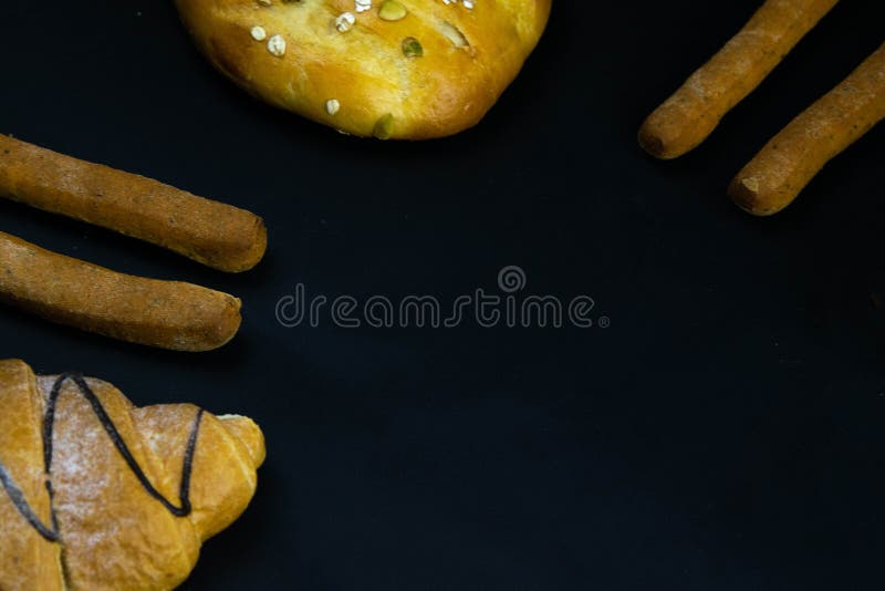 Different types of fresh bread with grain on a black rustic background. the bread stands around on top position royalty free stock photo