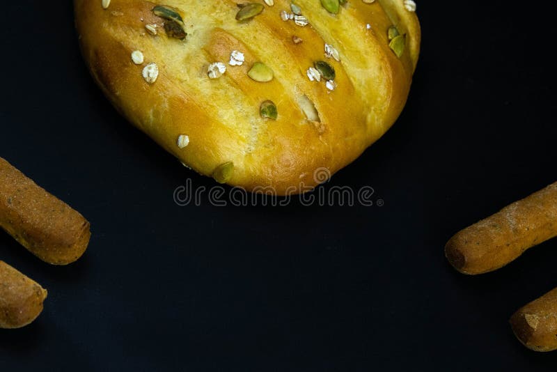 Different types of fresh bread with grain on a black rustic background. the bread stands around on top position stock photography
