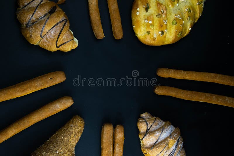 Different types of fresh bread with grain on a black rustic background. the bread stands around royalty free stock images