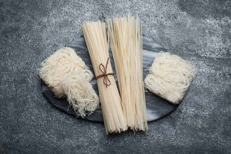 Different Uncooked Rice Noodles on Grey Table, Top View Stock Photo