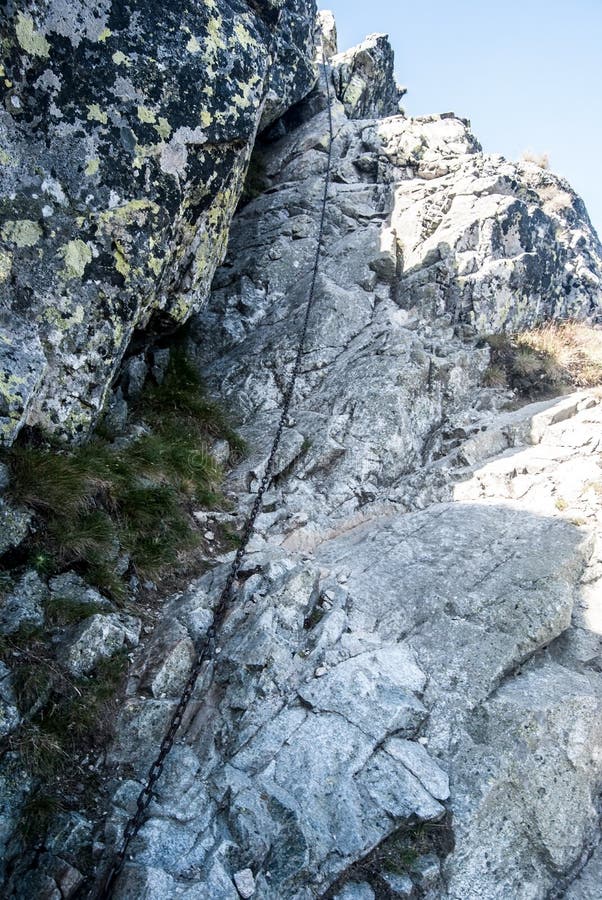 Obtížná turistická stezka po skalách zajištěných řetězem vede na vrchol Baníkov v Západních Tatrách na Slovensku