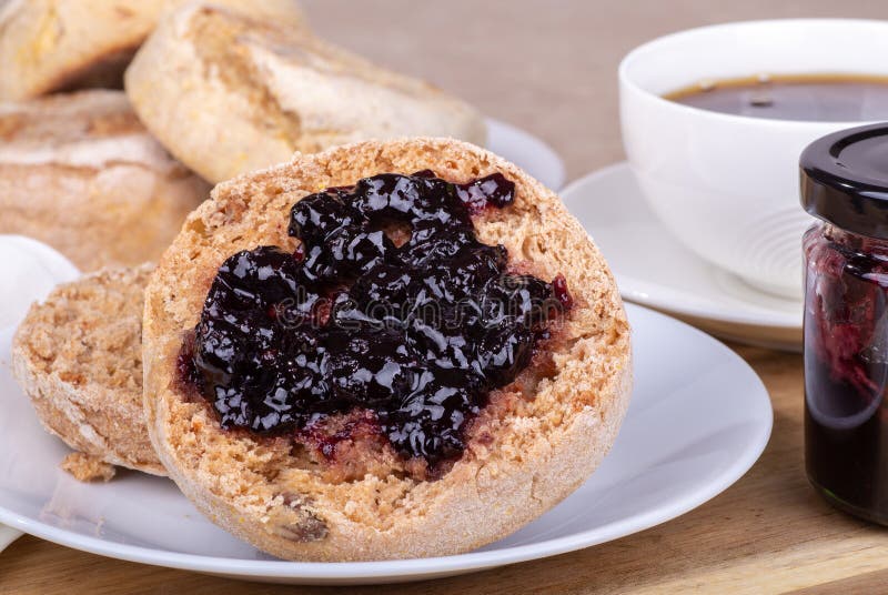 Diffusion de petit pain anglais avec de la confiture de myrtille images stock Diffusion de petit pain anglais avec de la confiture de myrtille images stock