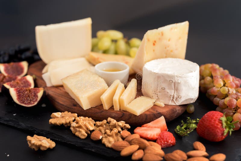 différents genres de fromages, de miel, de figues, d'écrous, de raisins, et de fruit sur une table Foyer sélectif Copiez l'espace photos stock différents genres de fromages, de miel, de figues, d'écrous, de raisins, et de fruit sur une table Foyer sélectif Copiez l'espace photos stock