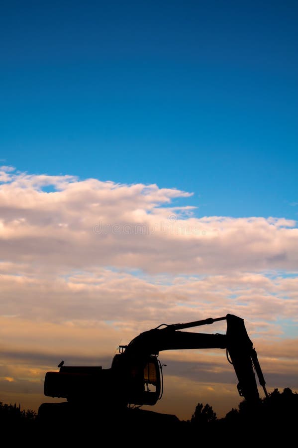 Silhouette of digger at sunset with vibrant blue sky. Silhouette of digger at sunset with vibrant blue sky