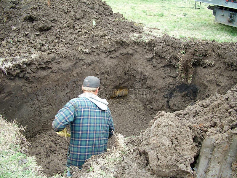 Costruzione di lavoro scavare un buco per un rifugio tempesta.