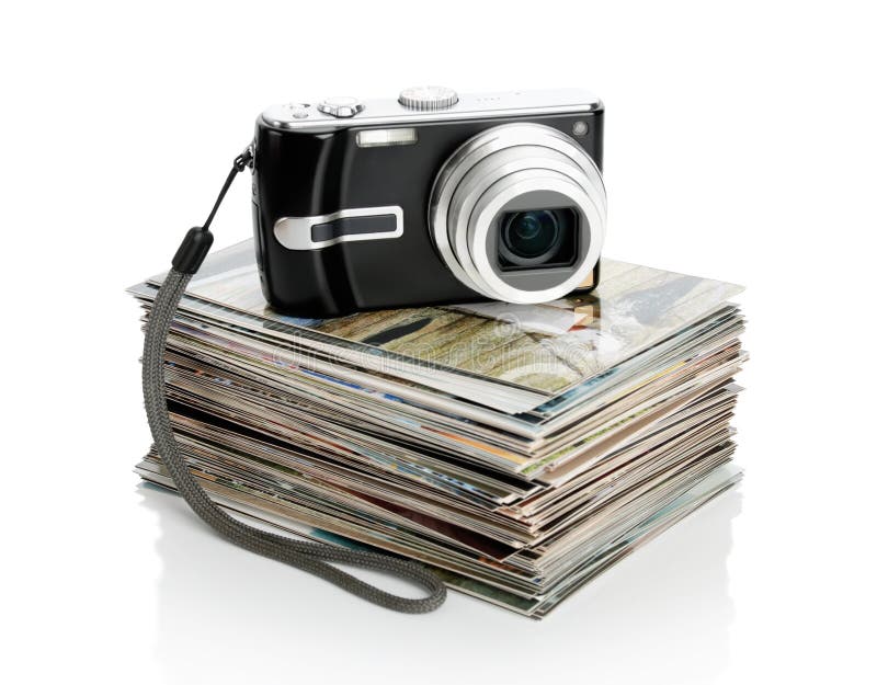 The digital camera and the heap of photos isolated on white
