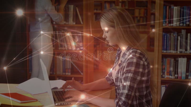Student using her laptop in library surrounded by data connections stock footage