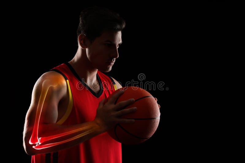 Digital composite of highlighted bones and basketball player with ball on black background stock image
