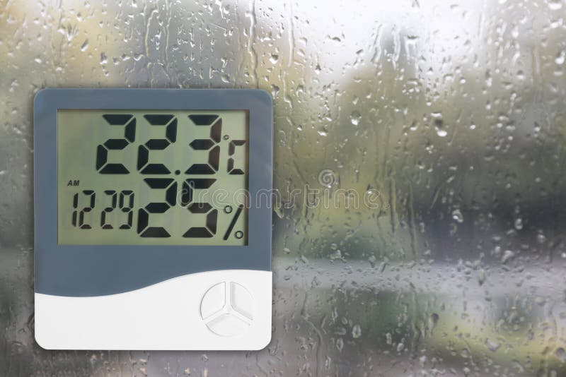 Digital Hygrometer with Thermometer on Glass with Water Drops. Space