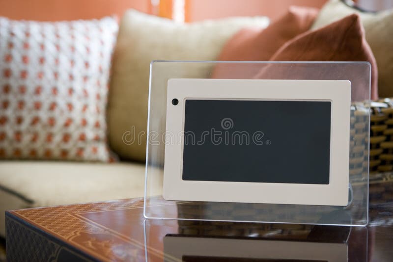 A blank digital picture frame for showing a photo slideshow sits in an elegant interior. A blank digital picture frame for showing a photo slideshow sits in an elegant interior.