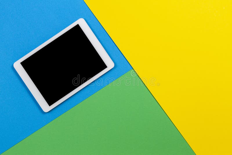 Digital Tablet Computer on Light Blue, Green and Yellow Background. Top