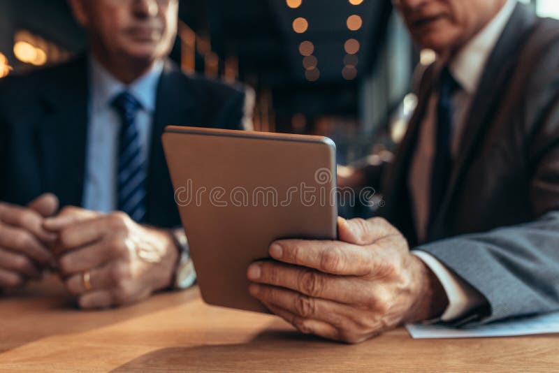 Digital tablet in hand of businessman talking to his partner stock photos Digital tablet in hand of businessman talking to his partner stock photos