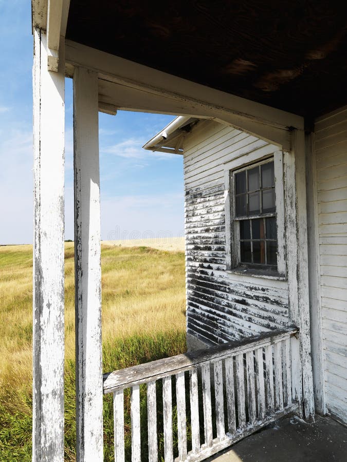 View from porch of weathered abandoned building in grassland. Dilapidated architecture stock images, royalty-free photos and pictures