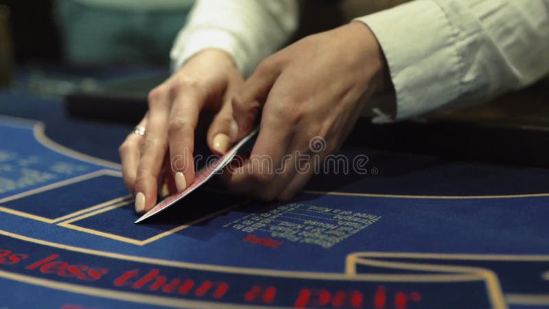 Diler rozdaje karty do gry na stole w kasynie