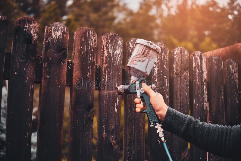 Diligent working is applying colour to the fence with airbrush