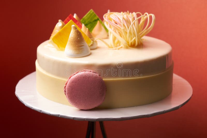 Dilite dessert cake on a white cake board. Close-up. Macaroon coconut almonds biscuit strawberry mousse lemon cream vanilla mousse white glazed chocolate stock photos