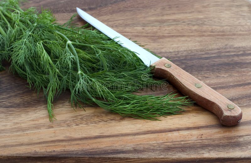 Dill and knife on a cutting board