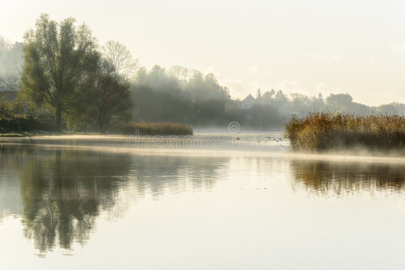 Dimmig höstmorgon med reflexioner i vattnet