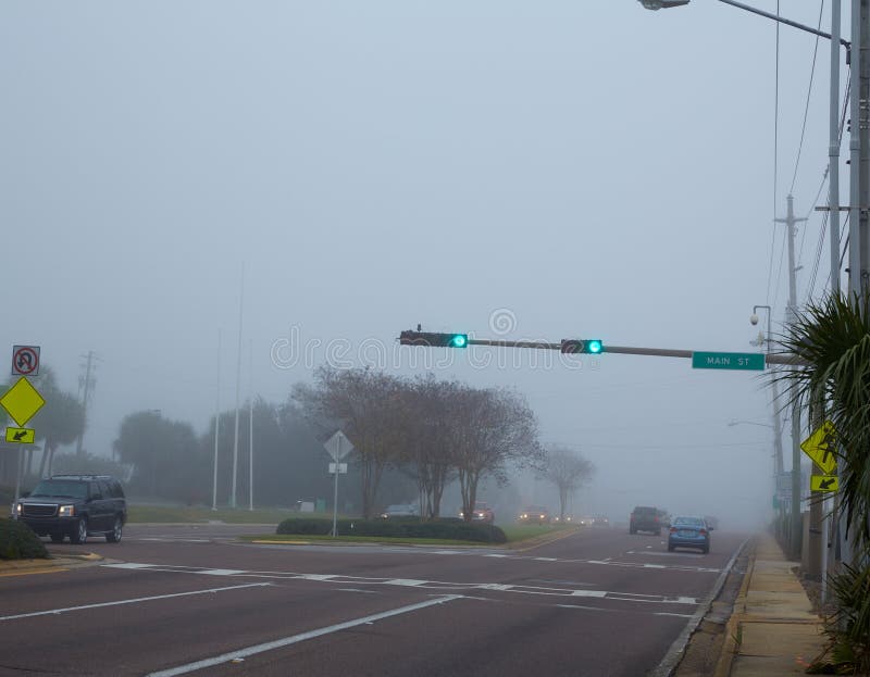 Dimmig ogenomskinlighetsmorgon i Florida med trafikbilar
