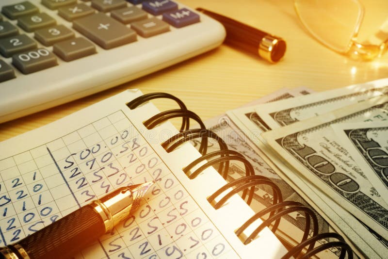 Dinero de presupuesto Libro con cálculos, la calculadora y los dólares fotografía de archivo libre de regalías Dinero de presupuesto Libro con cálculos, la calculadora y los dólares fotografía de archivo libre de regalías