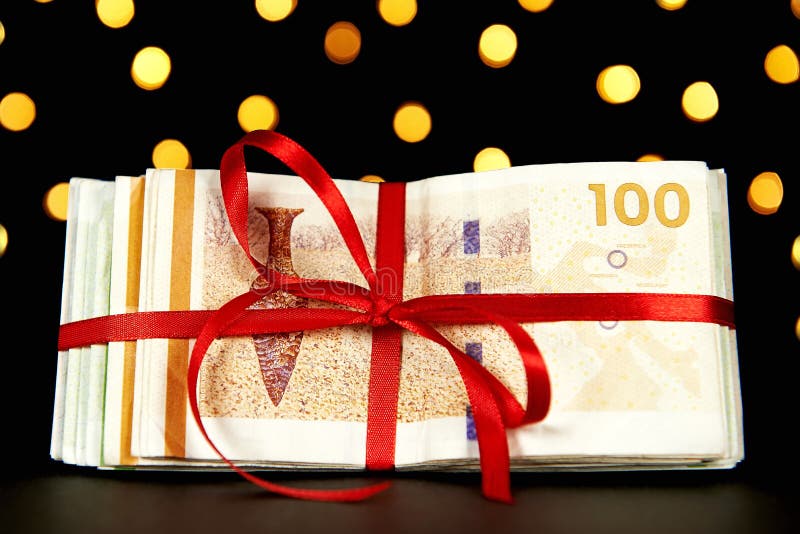 Dinero envuelto por un regalo de Navidad imágenes de archivo libres de regalías Dinero envuelto por un regalo de Navidad imágenes de archivo libres de regalías