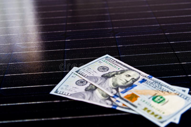 Dinero estadounidense en la superficie del panel solar. Cabeza cortada con una mueca asquerosa apuÃ±alada en la valla