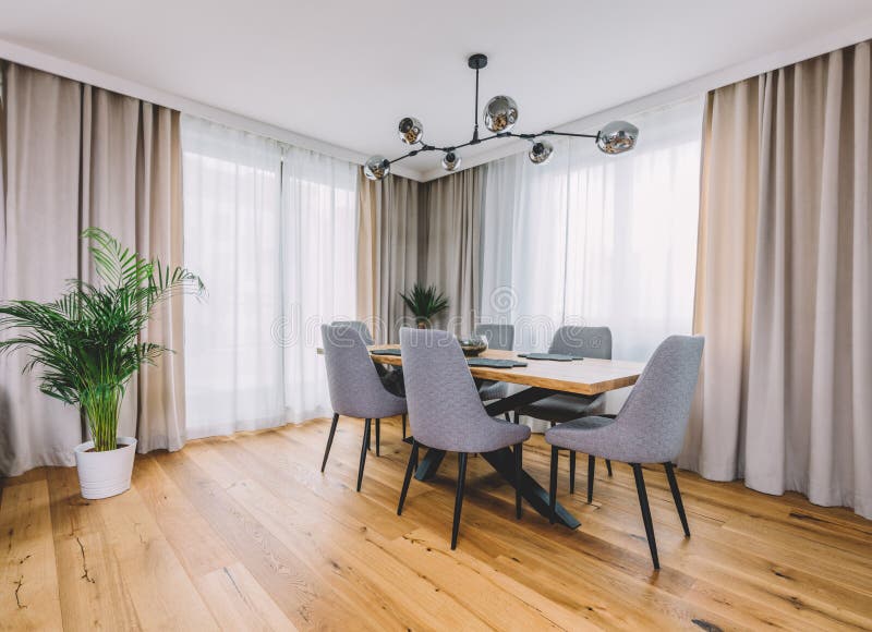 Dining Room with Wooden Table and Floor in Modern Apartment Stock Image