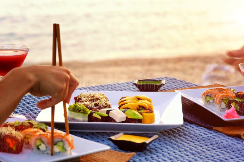 The Dinner with Japanese Sushi at the Beach on the Sunset Stock Photo